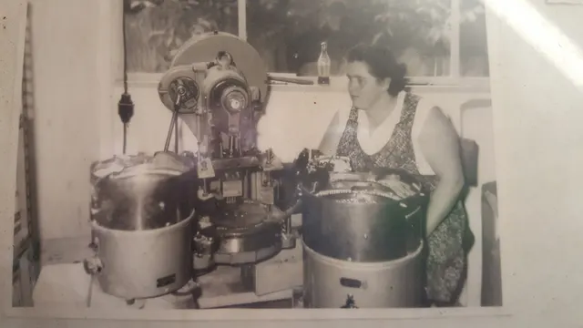 Mitarbeiterin an einer Stanzmaschine